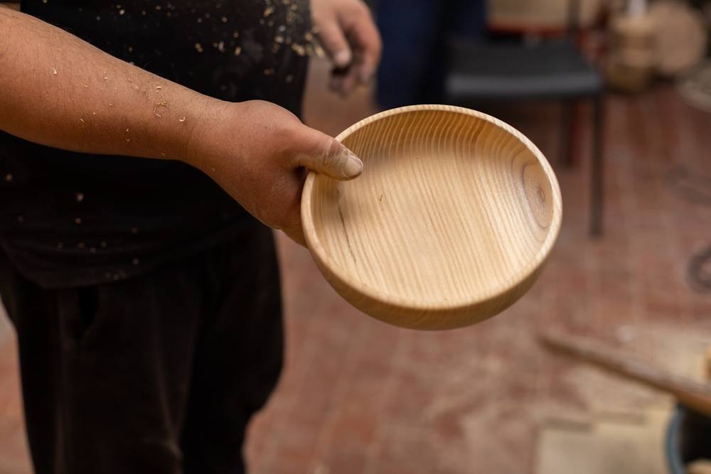 Une personne tenant un bol en bois.