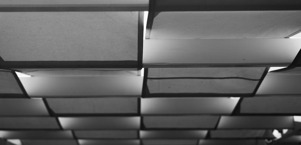 Plafond en carreaux de plâtre dans un bâtiment industriel.