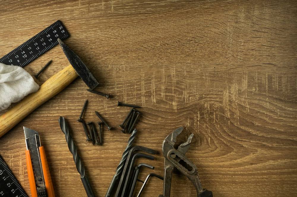 Outils de bricolage, vis et mètre sur établi en bois