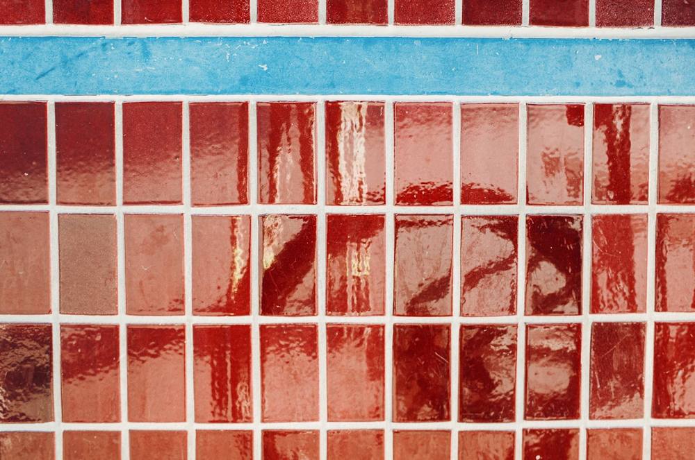 Carrelage mural rouge et bleu, motif géométrique, texture brillante.