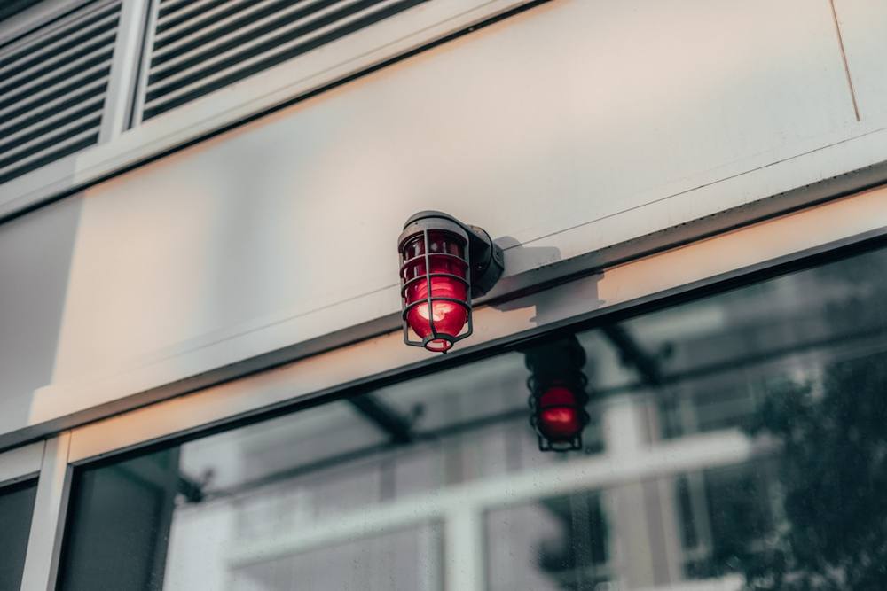 Lampe de sécurité rouge montée sur un mur.