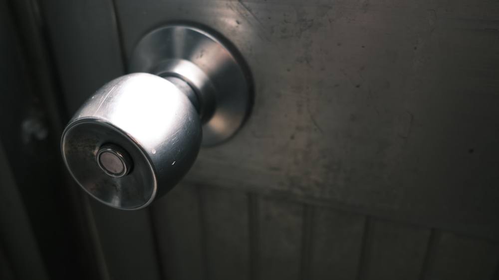 Poignée de porte en métal sombre dans un environnement sombre.