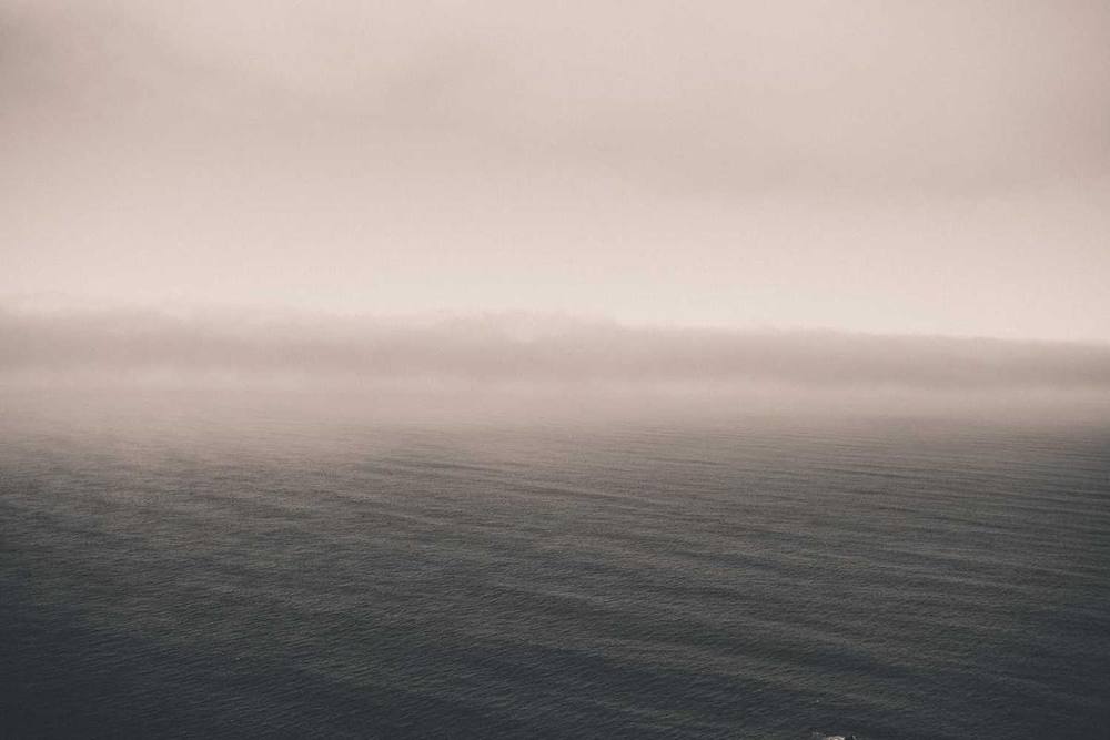 L'horizon océanique est obscurci par le brouillard et les nuages.