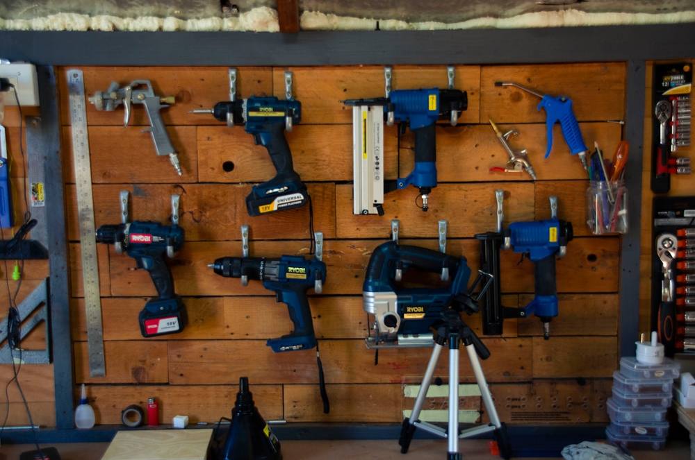 Un mur en bois avec des outils suspendus.