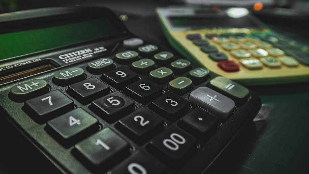Une calculatrice posée sur une table à côté d'une autre calculatrice.