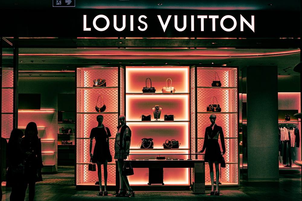 Magasin Louis Vuitton avec mannequins et sacs à main.