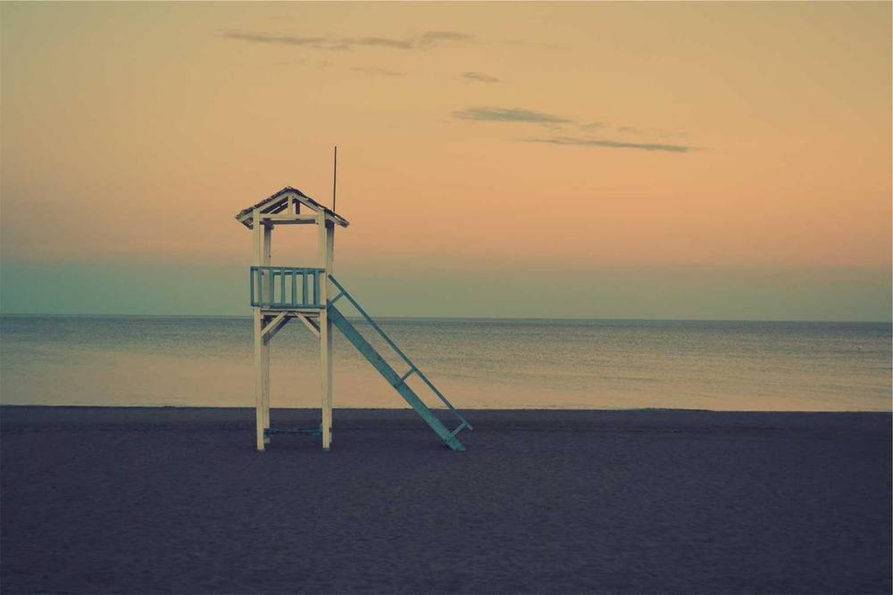 Lifeguard tower on beach overlooking ocean.