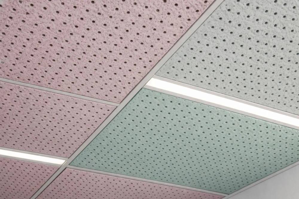 Gros plan sur les panneaux de plafond acoustique perforés dans un bureau moderne, montrant le matériau de laine minérale texturé avec des détails de surface absorbants, installation professionnelle avec éclairage LED intégré.