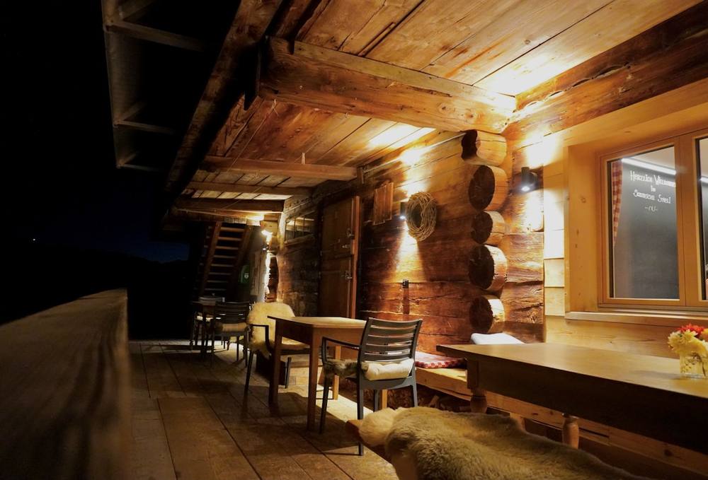 Intérieur rustique d'un chalet en bois avec tables et chaises.