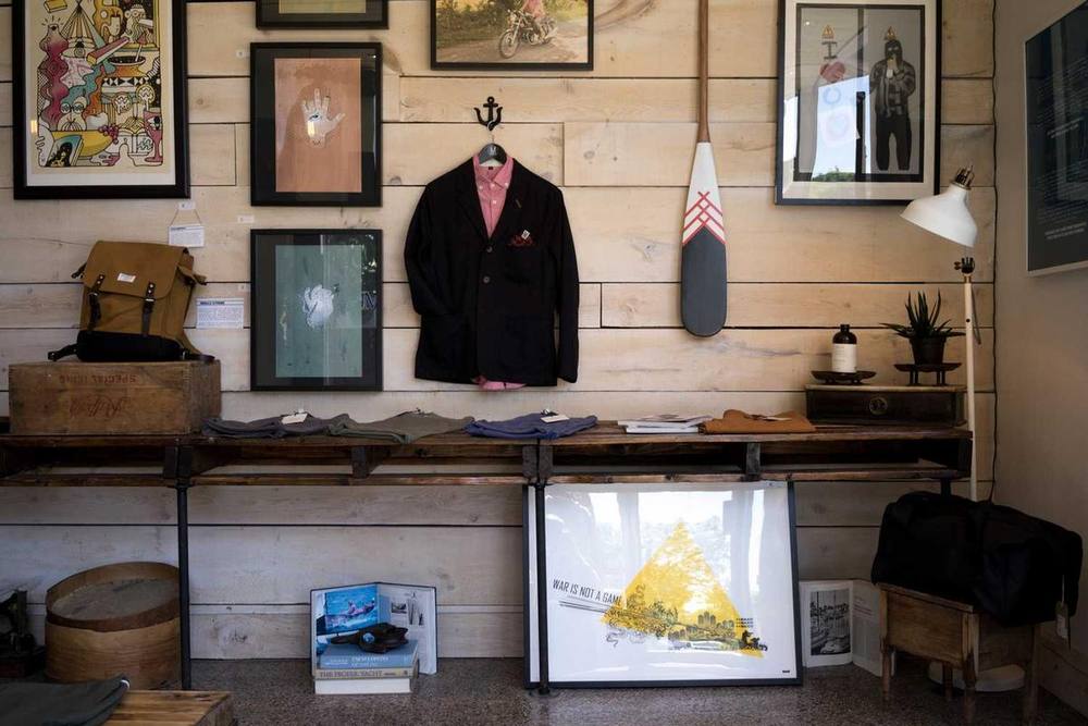 Présentoir de détail avec vêtements, œuvres d'art et accents en bois.