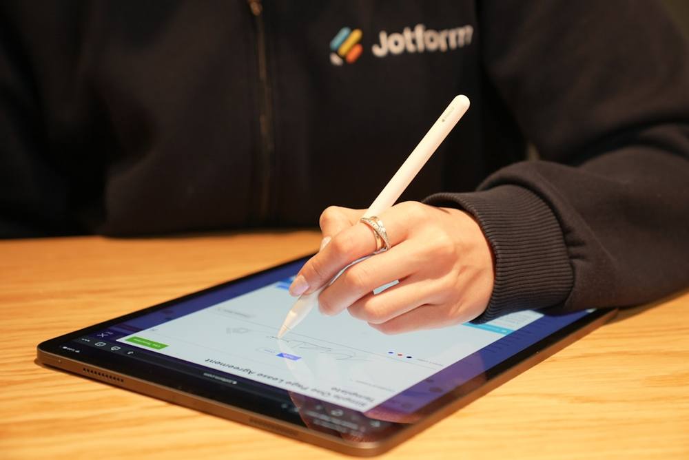 Une personne écrivant sur une tablette avec un stylo.
