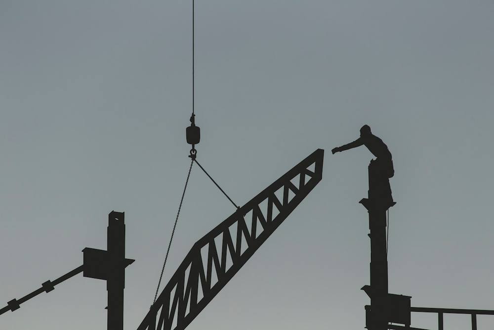 Silhouette d'un homme debout sur la grue à tour.