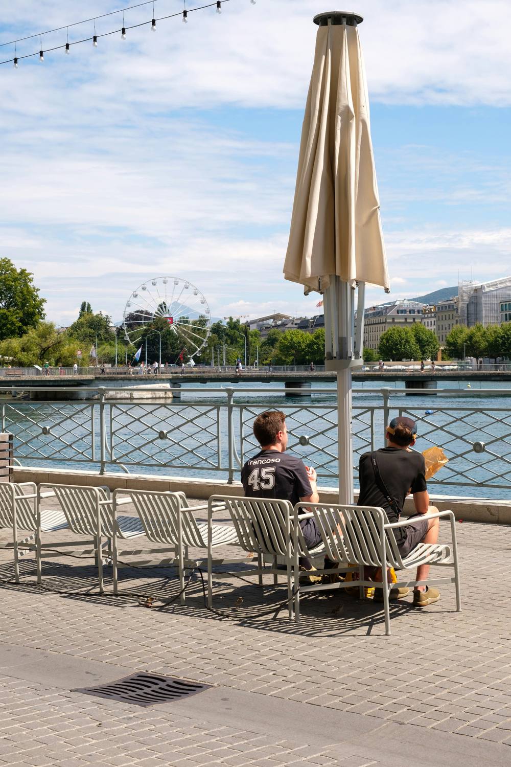 Un architecte discute des plans avec un couple dans un appartement de luxe avec vue sur le lac Léman.